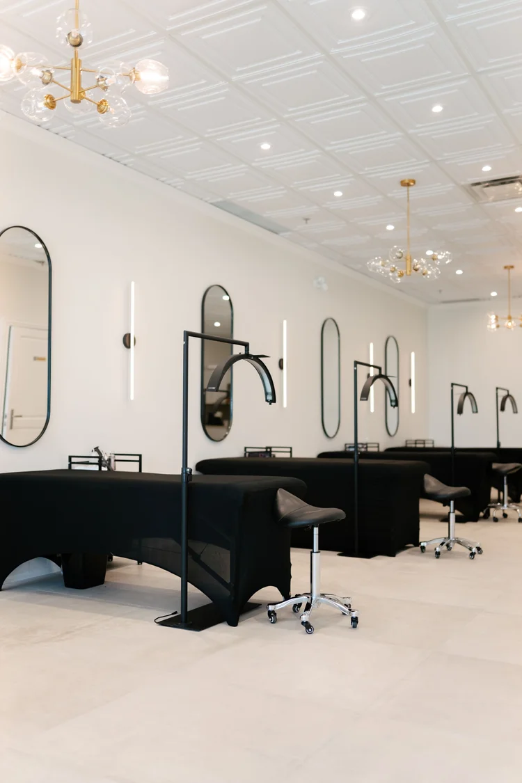 Bright, modern treatment room with black beds, oval mirrors and gold lighting at MADEBYMCHL